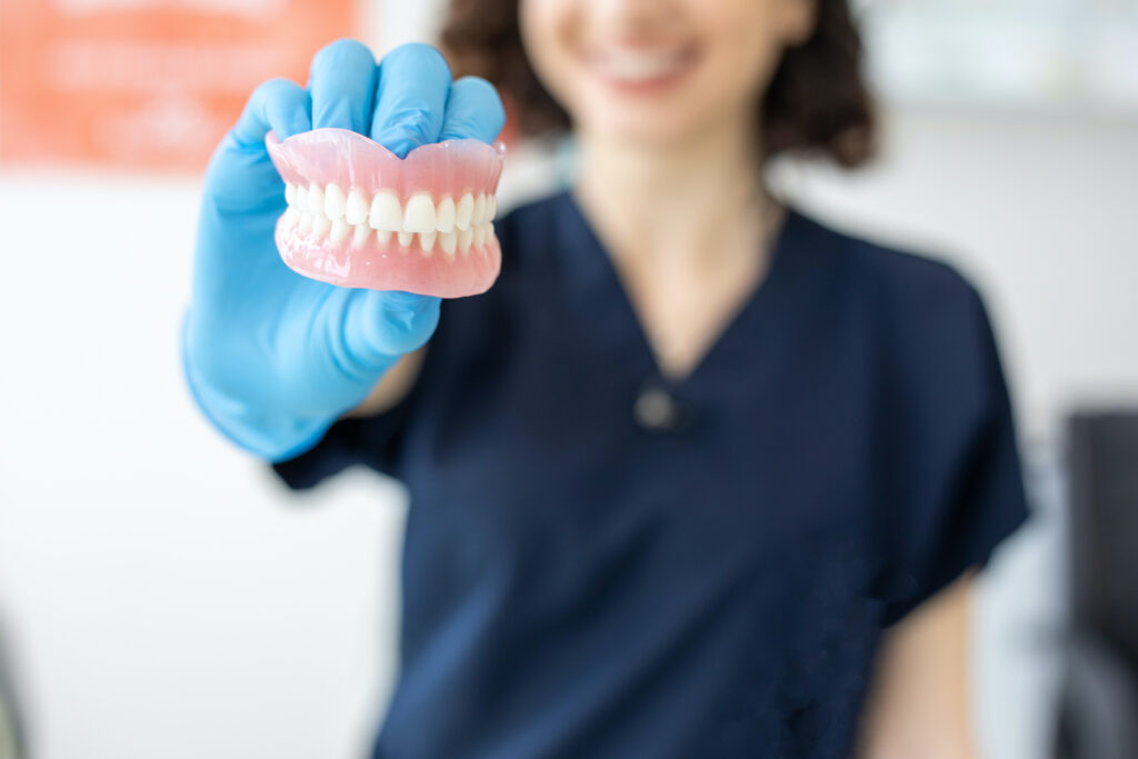 A dentist holding a set of dentures